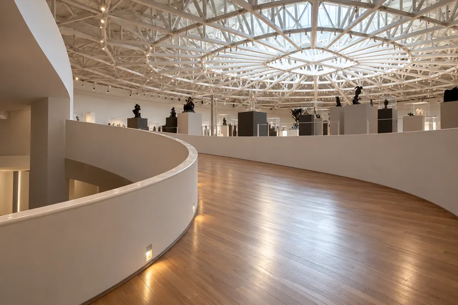 Zakrzywiona rampa o gładkiej nawierzchni i biała balustrada wewnątrz Museo Soumaya